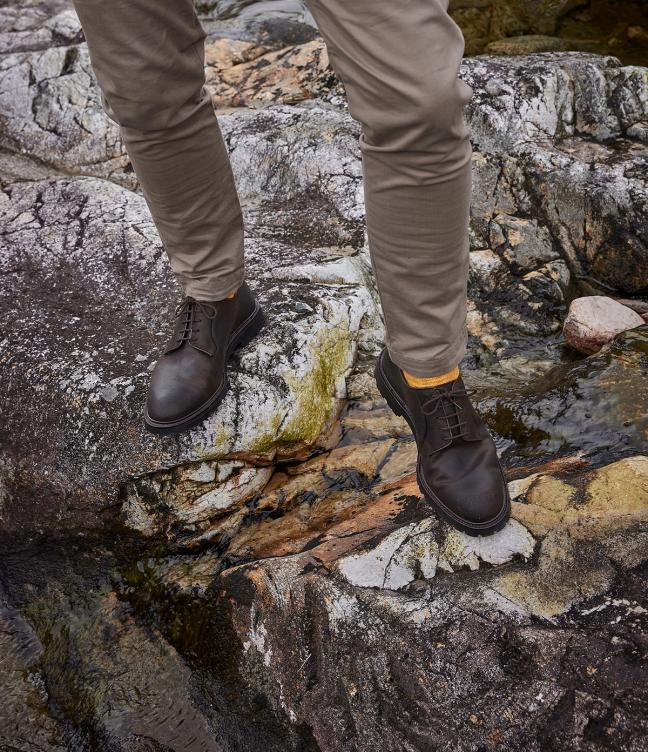 Man wearing Crockett & Jones Lanark 3 shoes in Dark Brown Rough-Out Suede around the Trossachs