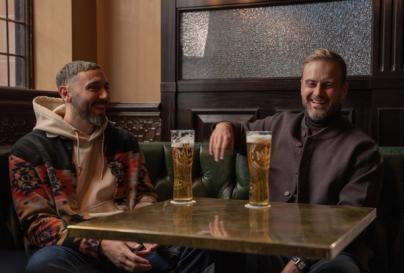 Two men sharing Monte Carlo Beer at a table