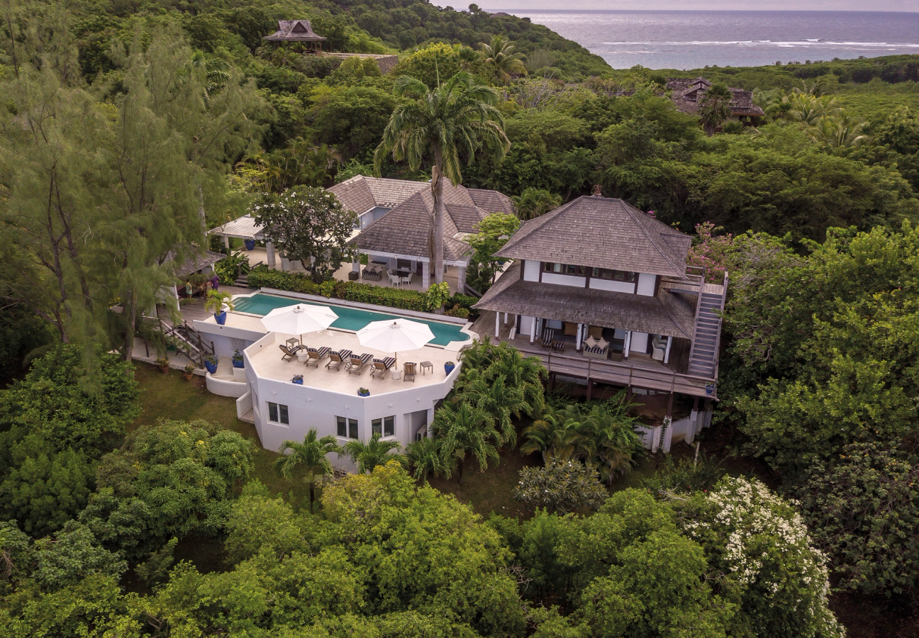 Balinese-style villa in the hills of Mustique surrounded by trees with far-reaching sea views