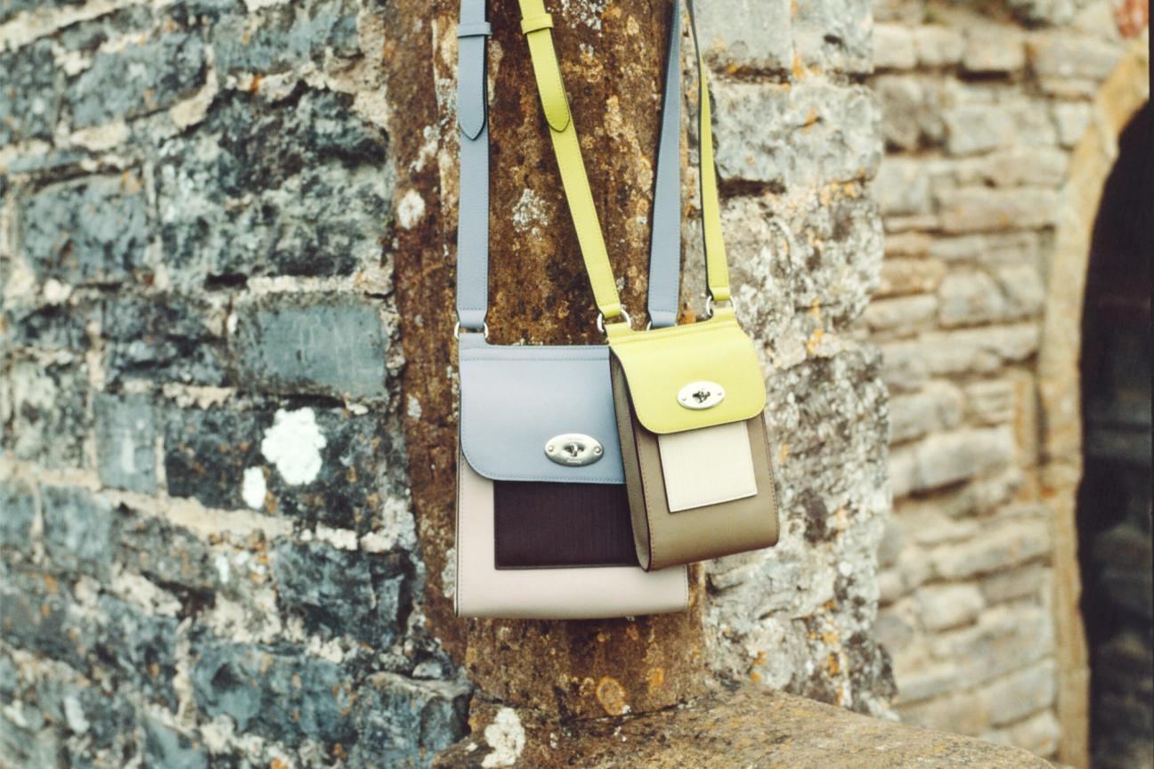Mulberry Antony bag and Mini Antony bag in Paul Smith colour combinations hanging on a stone brick wall