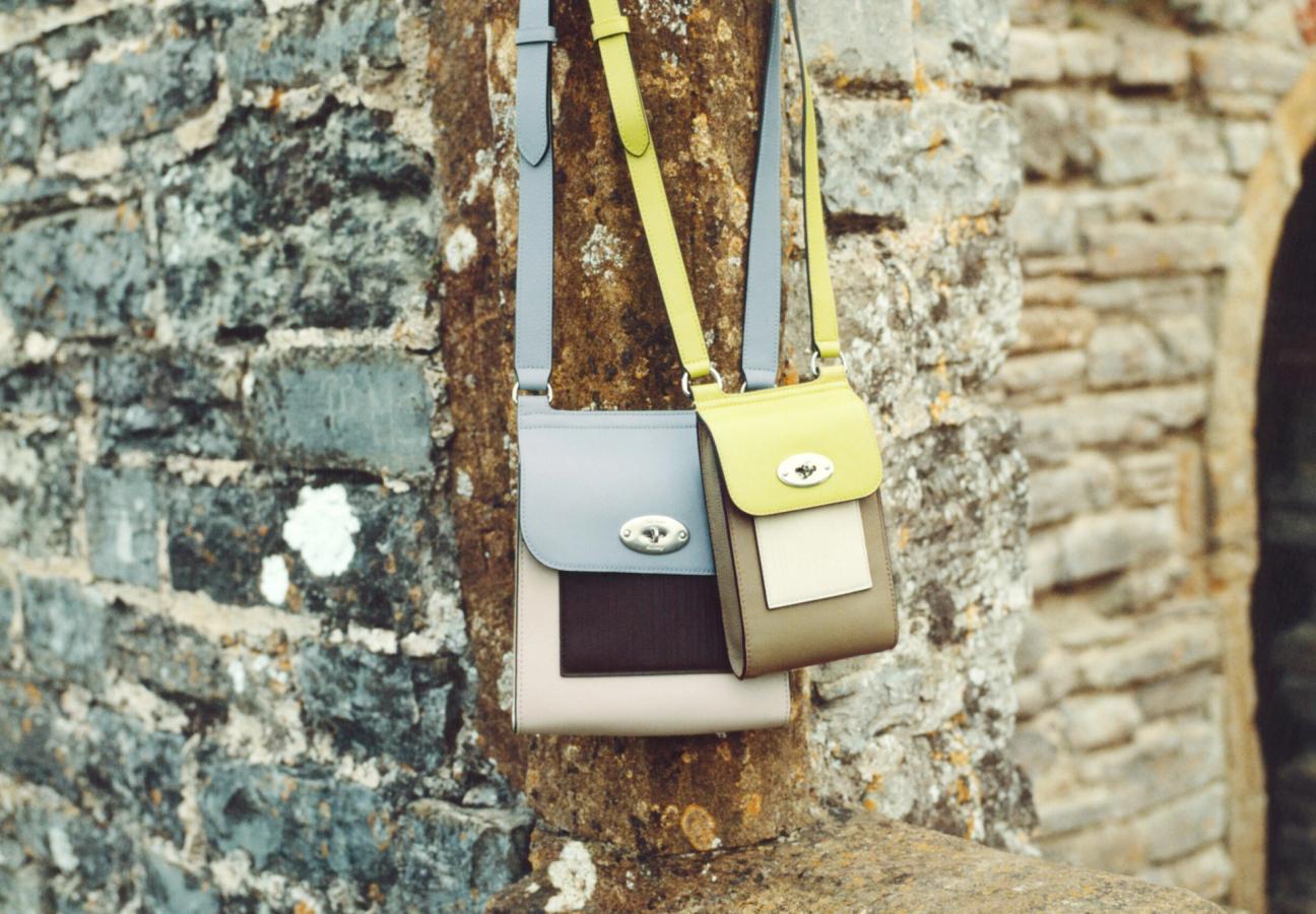 Mulberry Antony bag and Mini Antony bag in Paul Smith colour combinations hanging on a stone brick wall