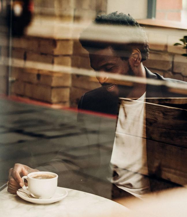 man sat in cafe drinking coffee