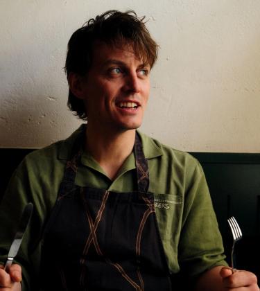 Tom Straker holing a knife and fork