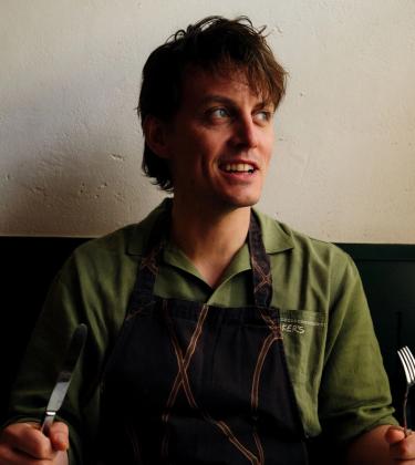 Tom Straker holing a knife and fork