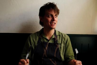 Tom Straker holing a knife and fork