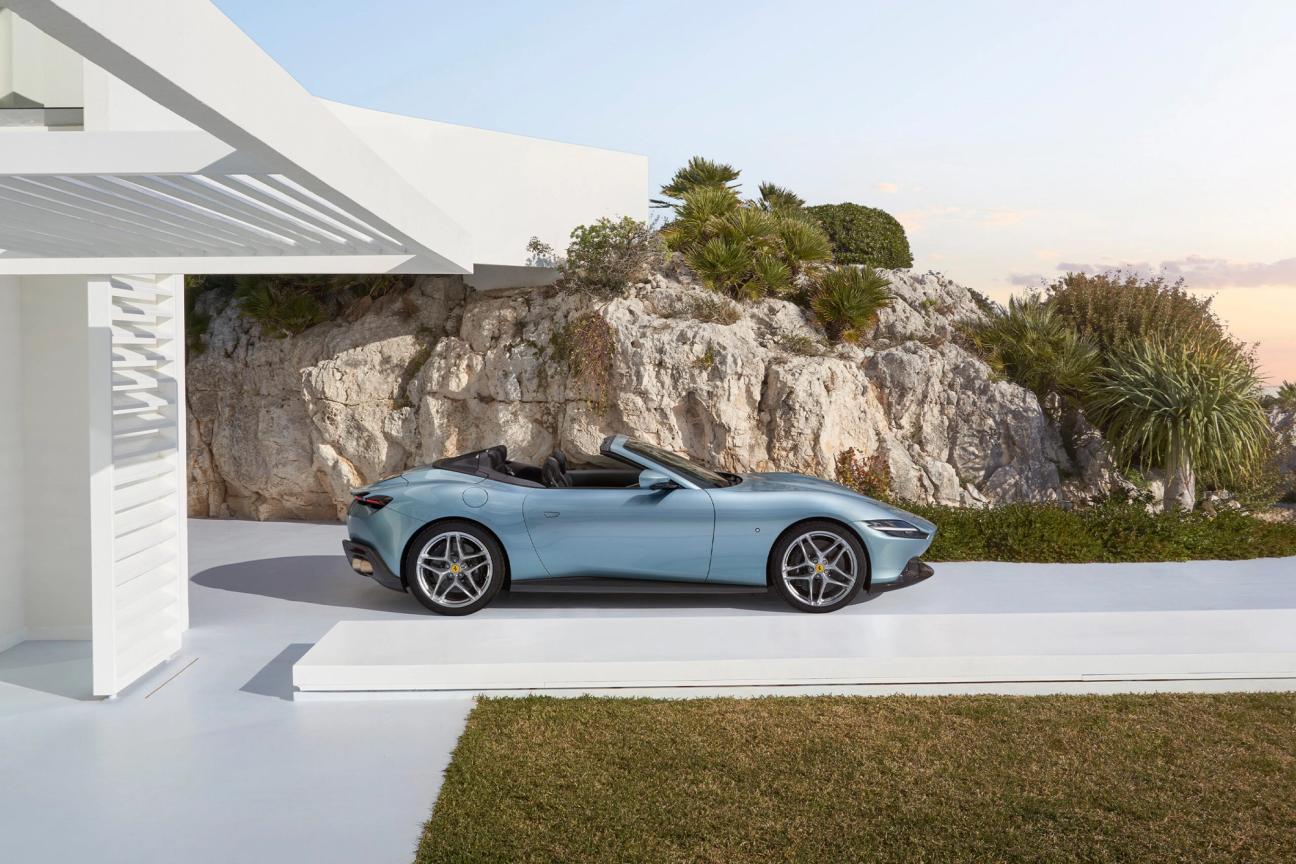 Side profile of Ferrari Roma Spider, pulling out of the coastal driveway
