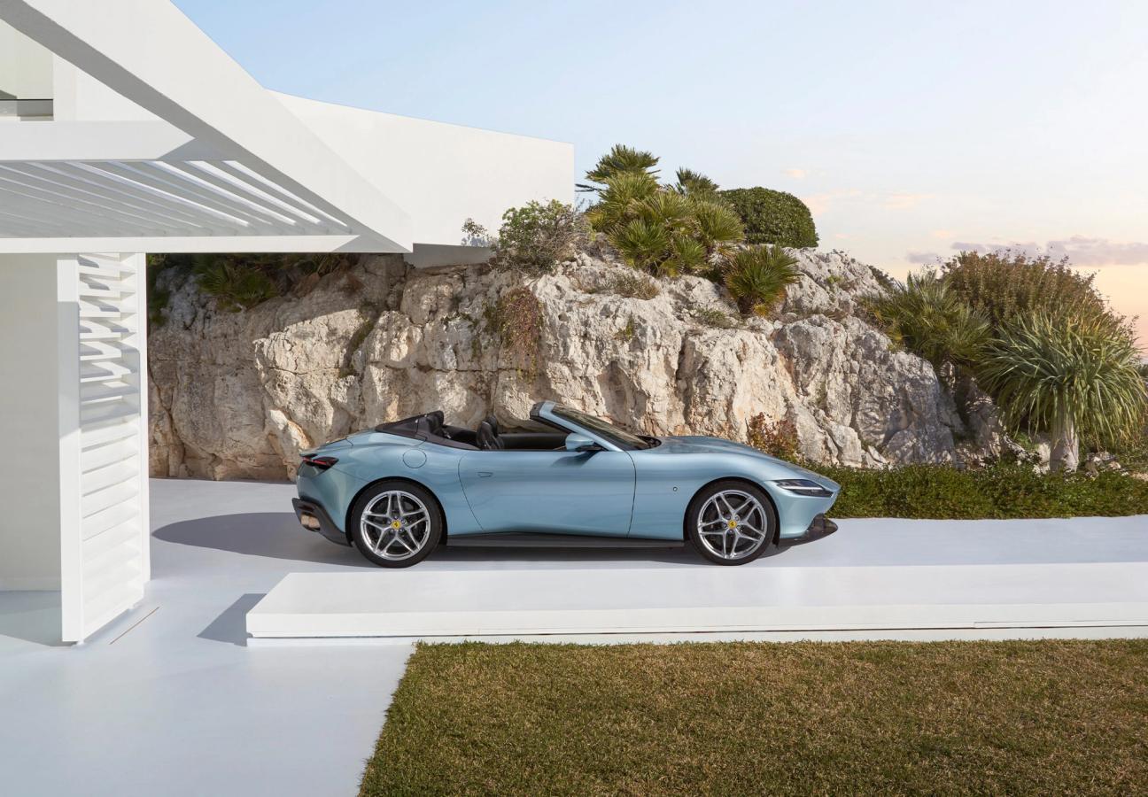 Side profile of Ferrari Roma Spider, pulling out of the coastal driveway