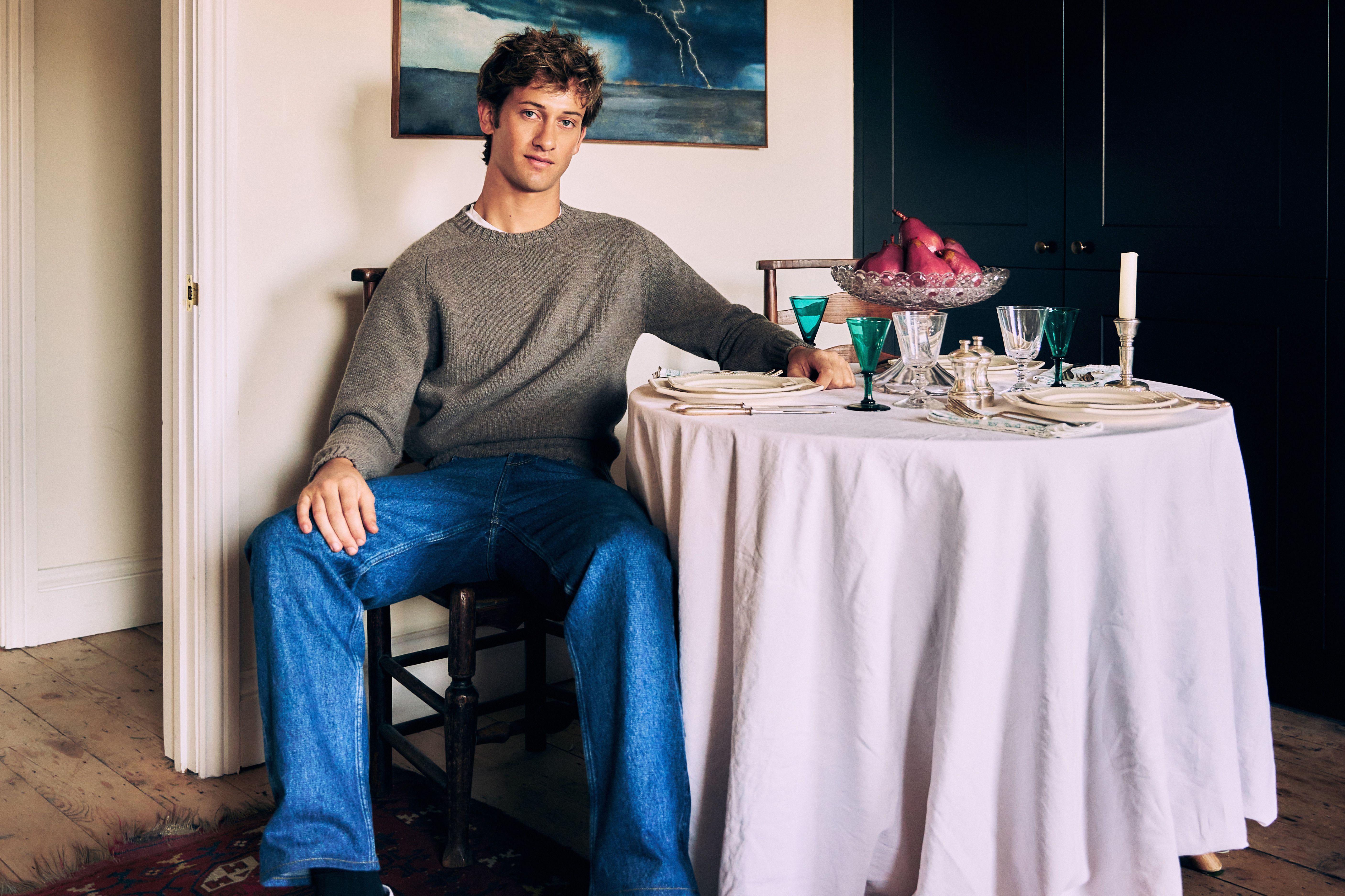 Jamie Sharp seated beside a table set with antique glassware