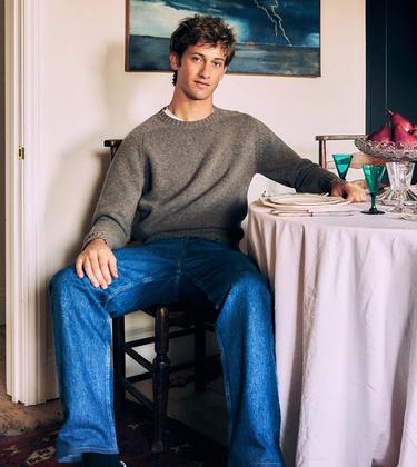 Jamie Sharp seated beside a table set with antique glassware