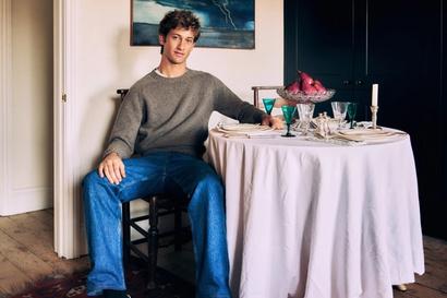 Jamie Sharp seated beside a table set with antique glassware
