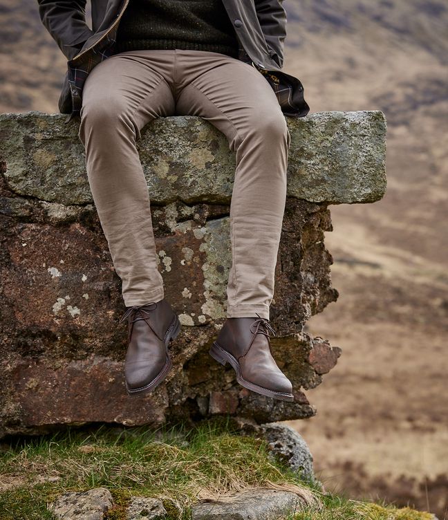 Man wearing Crockett & Jones’s Dark Brown Rough-Out Suede chukka boot out in the countryside hills