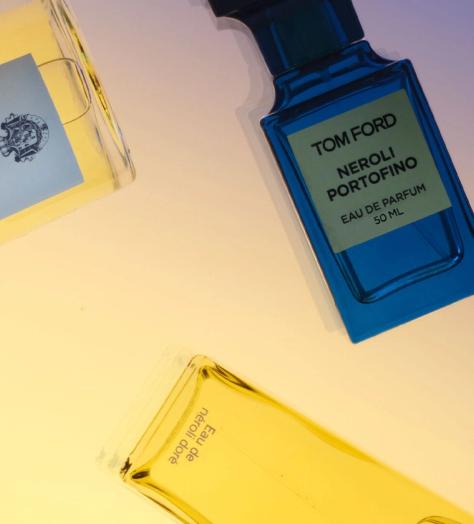 Scattered fragrance bottles including Acqua di Parma, Tom Ford Neroli Portofino and Creed Erolfa