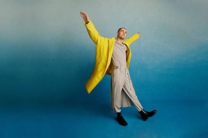 Jonah Hauer-King wearing a yellow jacket in front of a blue studio background
