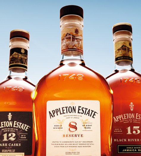 Five bottles of Appleton Estate rum in a field