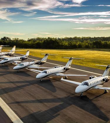 A row of Cessna Citation business jets lined up on a runway