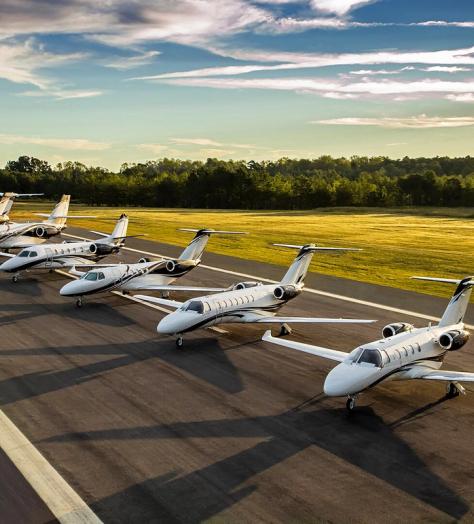 A row of Cessna Citation business jets lined up on a runway