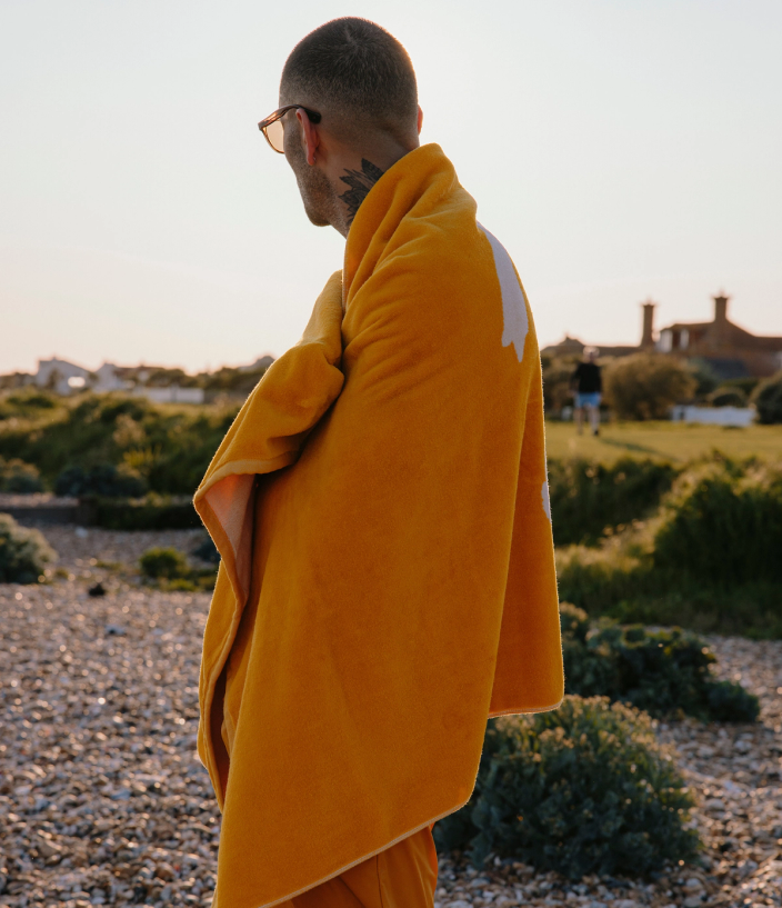 Tracksmith model, wearing an orange towel