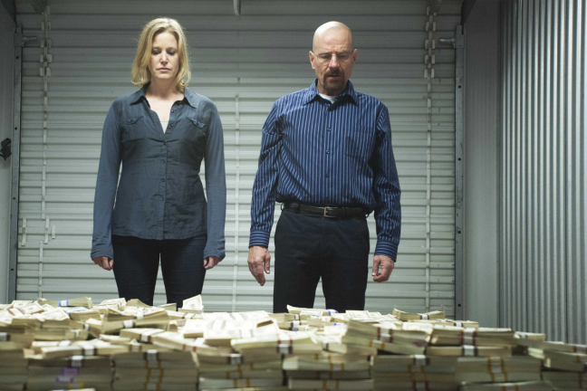 Walter White looking at piles of money in Breaking Bad