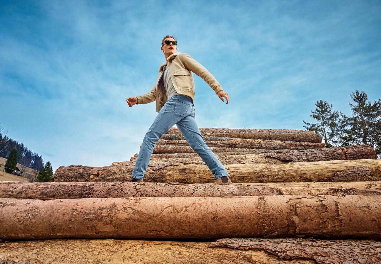 Man walking on log piles in Mr Marvis jeans