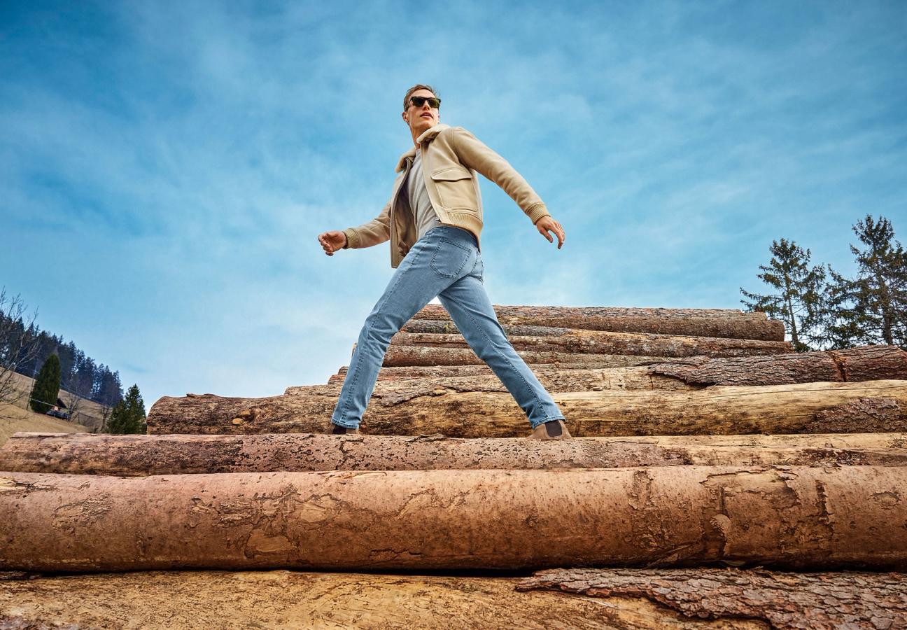 Man walking on log piles in Mr Marvis jeans
