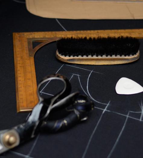 Tailoring table with fabric markings, scissors, brush and right angle ruler