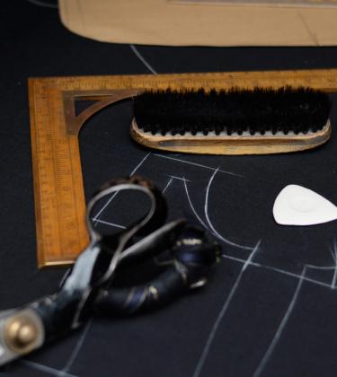 Tailoring table with fabric markings, scissors, brush and right angle ruler