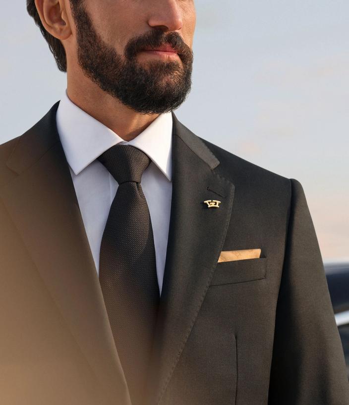 Chauffeur wearing a suit with Wheely logo pin