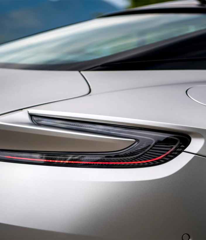 Headlights of a silver Aston Martin DB12