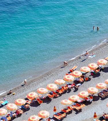 Positano Beach with rows of orange umbrellas on the Amalfi Coast