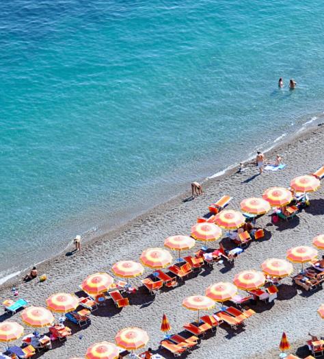 Positano Beach with rows of orange umbrellas on the Amalfi Coast