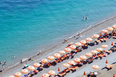 Positano Beach with rows of orange umbrellas on the Amalfi Coast