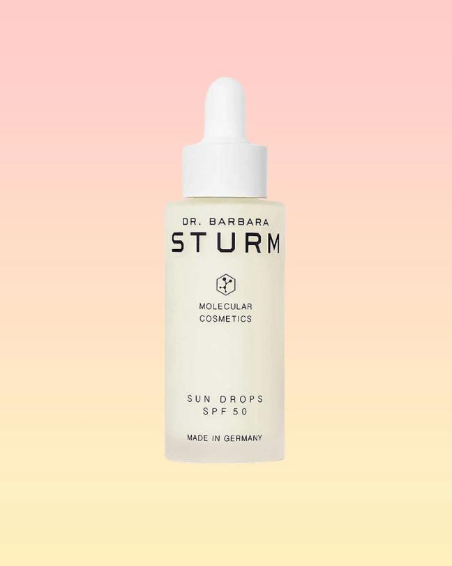 Dr. Barbara Sturm Sun Drops SPF50 bottle on a pink and yellow background