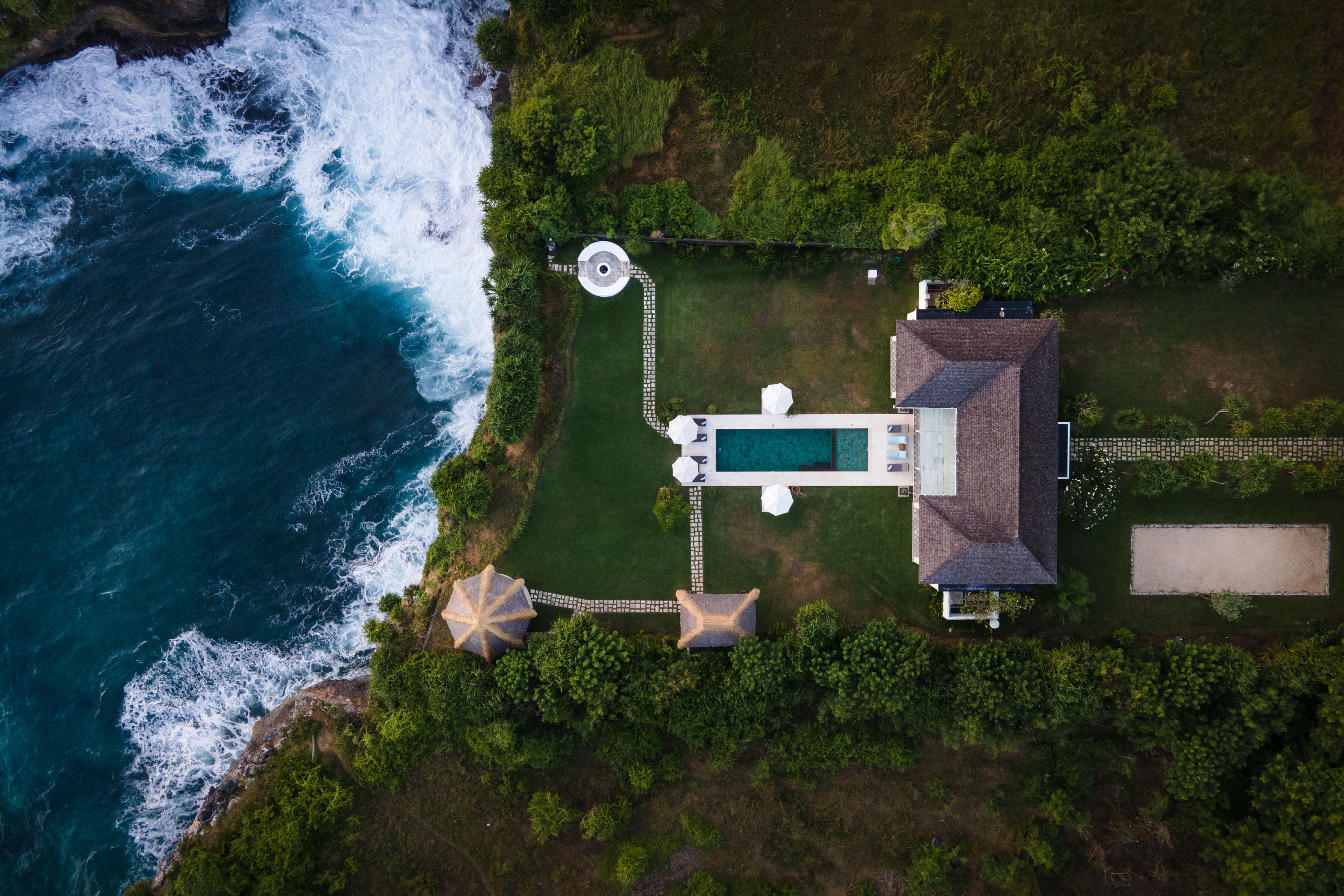 Aerial view of the clifftop villa and pool beside the ocean on Nusa Lembongan