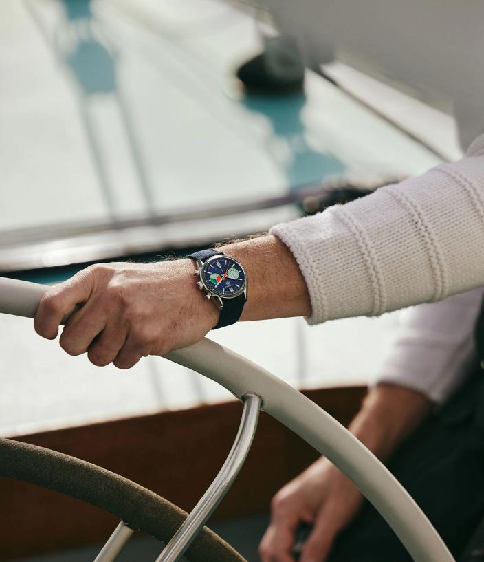 Man steering a boat wearing the TAG Heuer Carrera Skipper