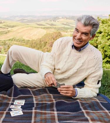 Pierce Brosnan and his son Paris Brosnan playing cards on a picnic blanket wearing Paul&Shark’s jumpers