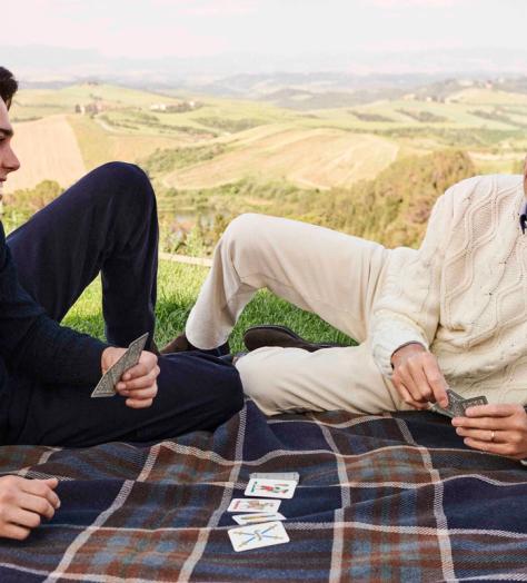 Pierce Brosnan and his son Paris Brosnan playing cards on a picnic blanket wearing Paul&Shark’s jumpers
