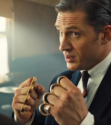 Tom Hardy with clenched fists held up wearing knuckle dusters