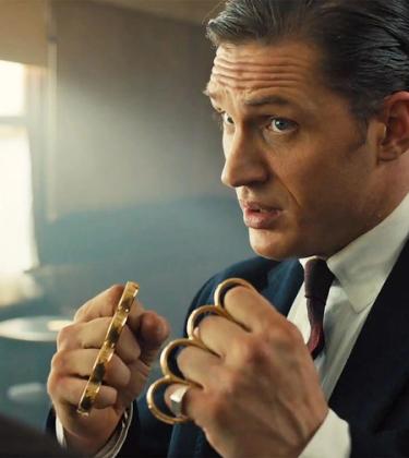Tom Hardy with clenched fists held up wearing knuckle dusters