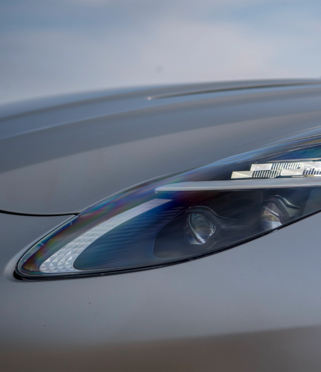 Headlights of a silver Aston Martin DB12