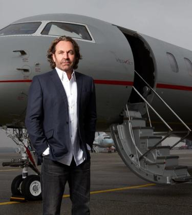 Thomas Flohr standing in front of his private jet