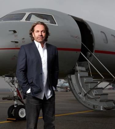 Thomas Flohr standing in front of his private jet