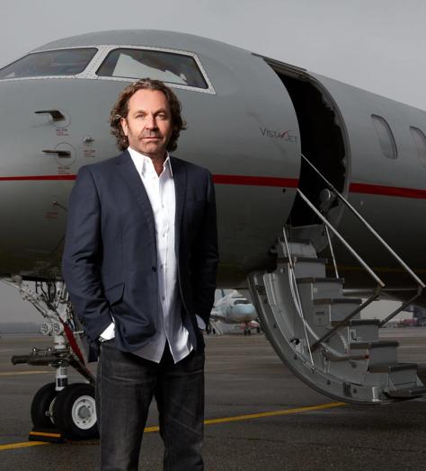 Thomas Flohr standing in front of his private jet