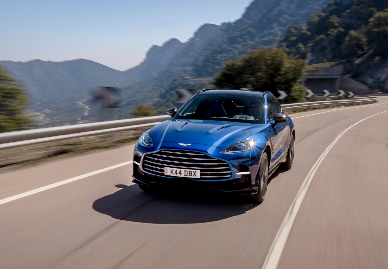 Blue Aston Martin DBX 707 driving along a mountain road