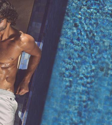 model wears swim shorts by the poolside, photographed by Adam Fussell for Gentleman's Journal