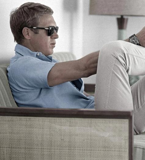 steve mcqueen wearing polo shirt and trainers pointing a gun