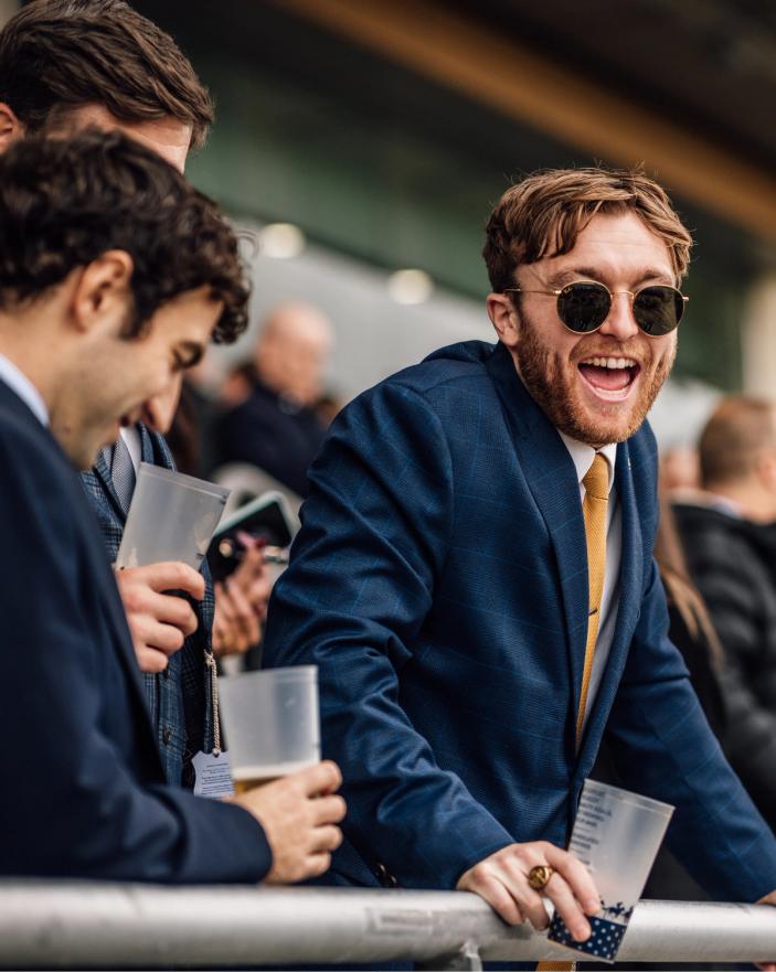 Racegoers in suits enjoying British Champions Day