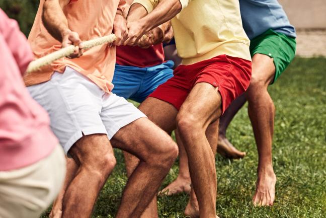 Group of people playing tug of war wearing various bright coloured Mr Marvis shorts