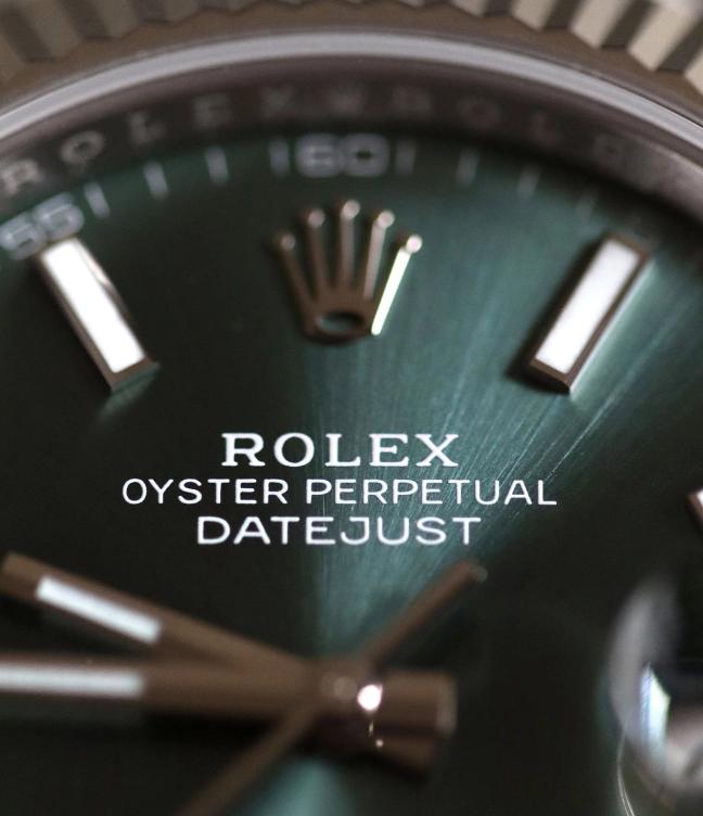 Close up of Rolex with green watch face 