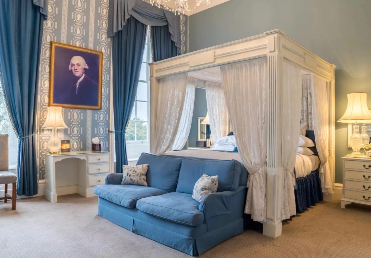 Four-poster bedroom with blue upholstery at Stapleford Park