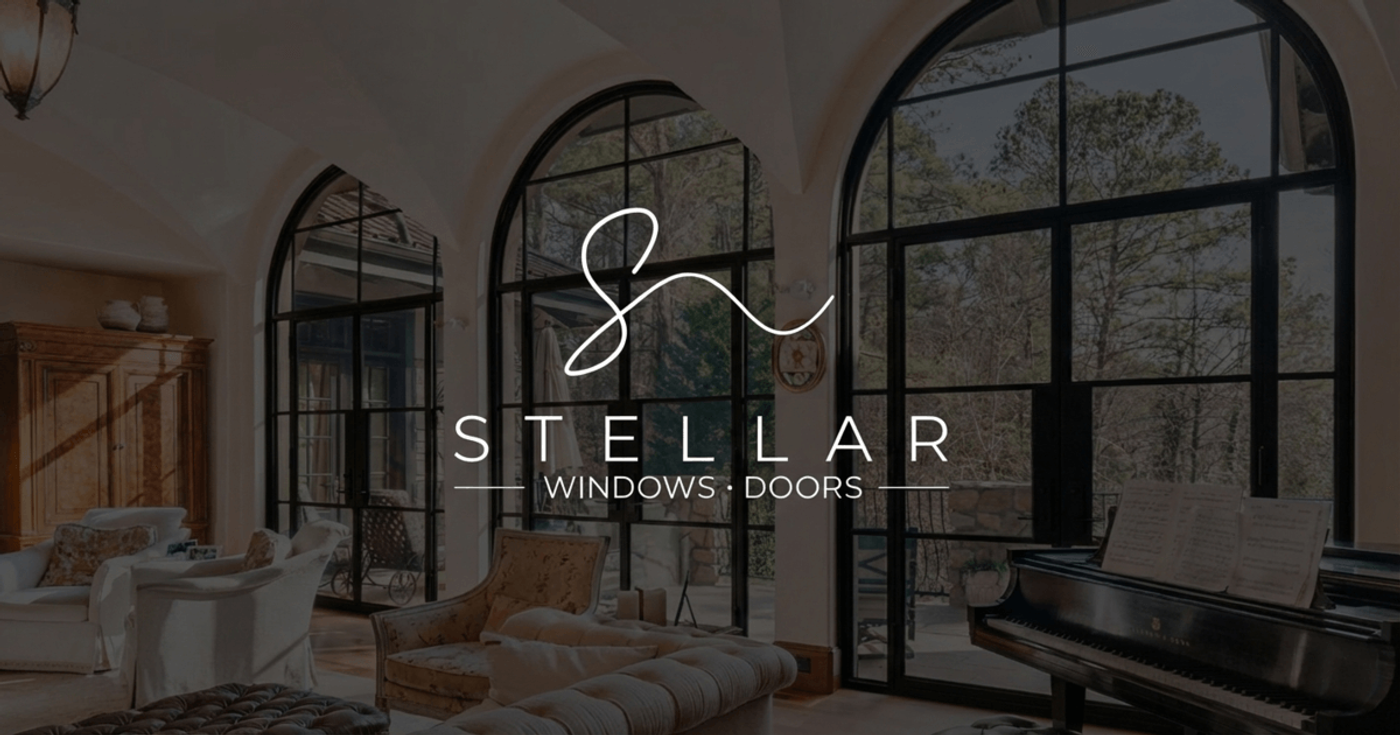 The Stellar Windows and Doors logo over a room with tall arched black-framed windows and a grand piano.